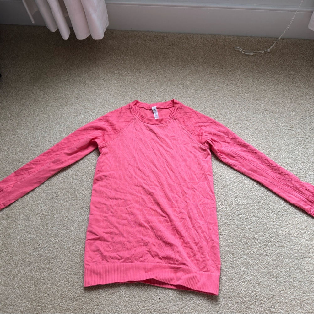 Pink women’s lulu long sleeve shirt with textured pattern.